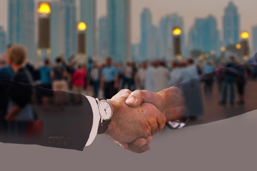 Image of two arms shaking hands.